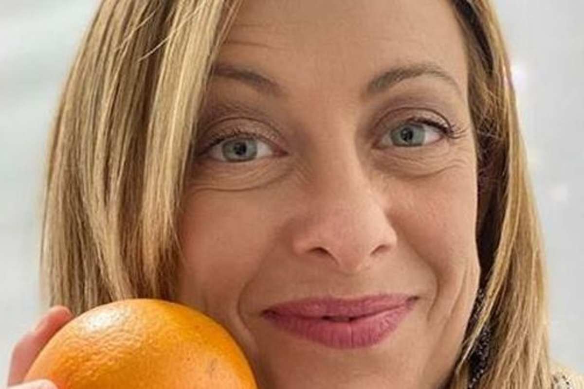 Giorgia Meloni con un'arancia